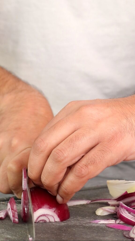 chopping a red onion on a chopping board