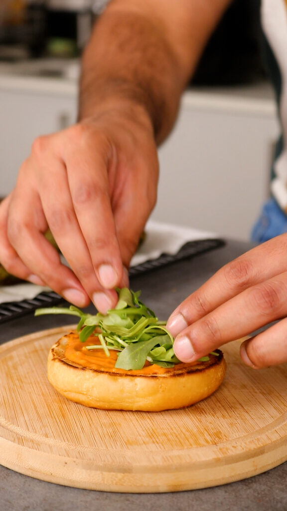 burger bun with chilli garlic mayonnaise and rocket on top