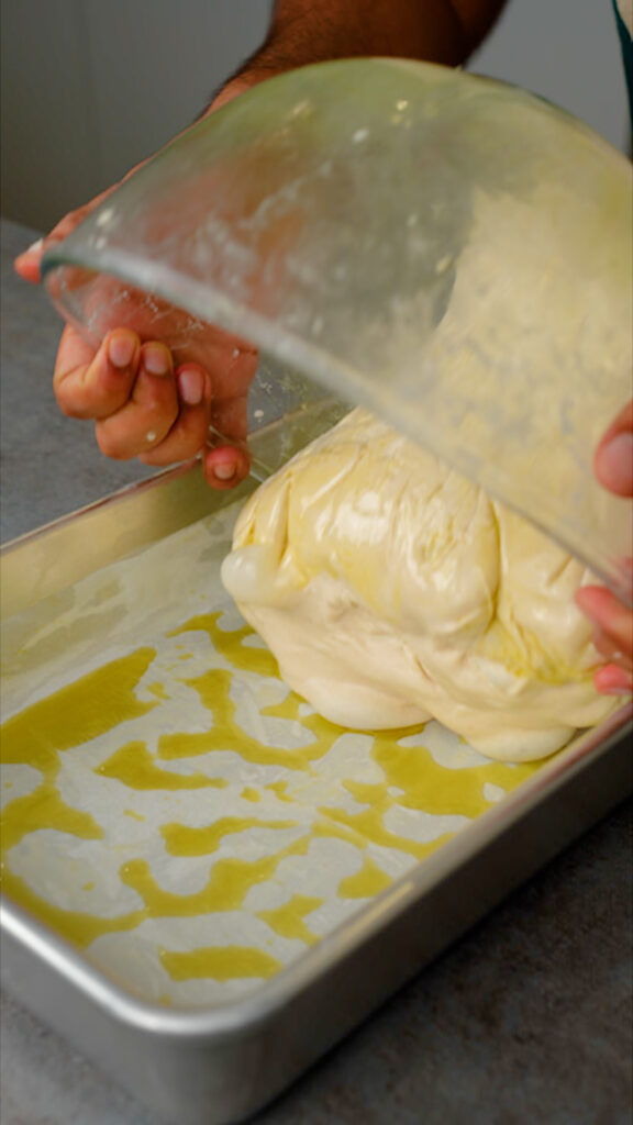 transferring focaccia dough into tin