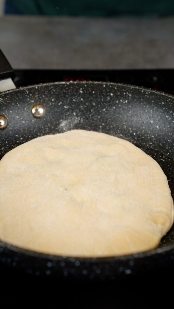 cooking naan in a pan