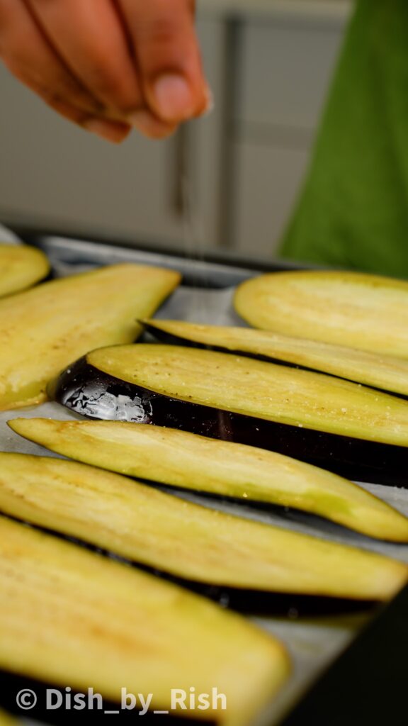 sprinkling salt on the aubergine slices