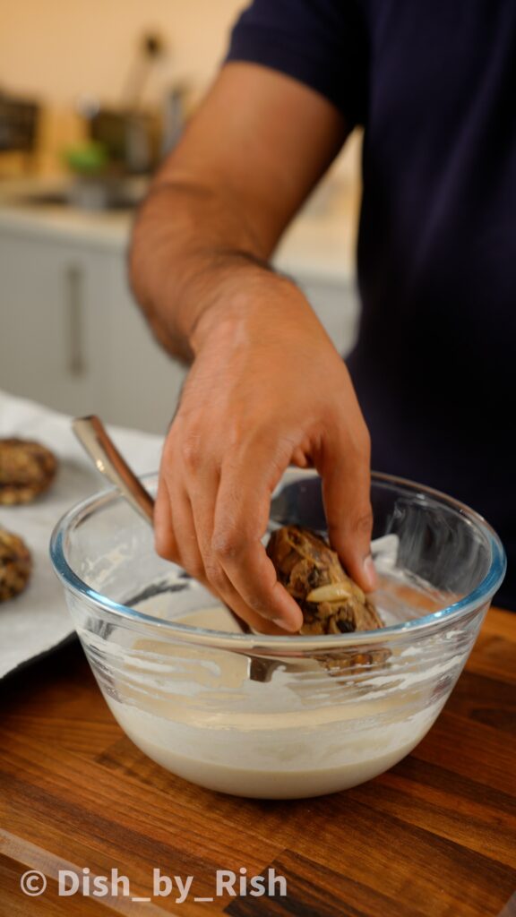 dunking mushroom burger patty into flour and water paste