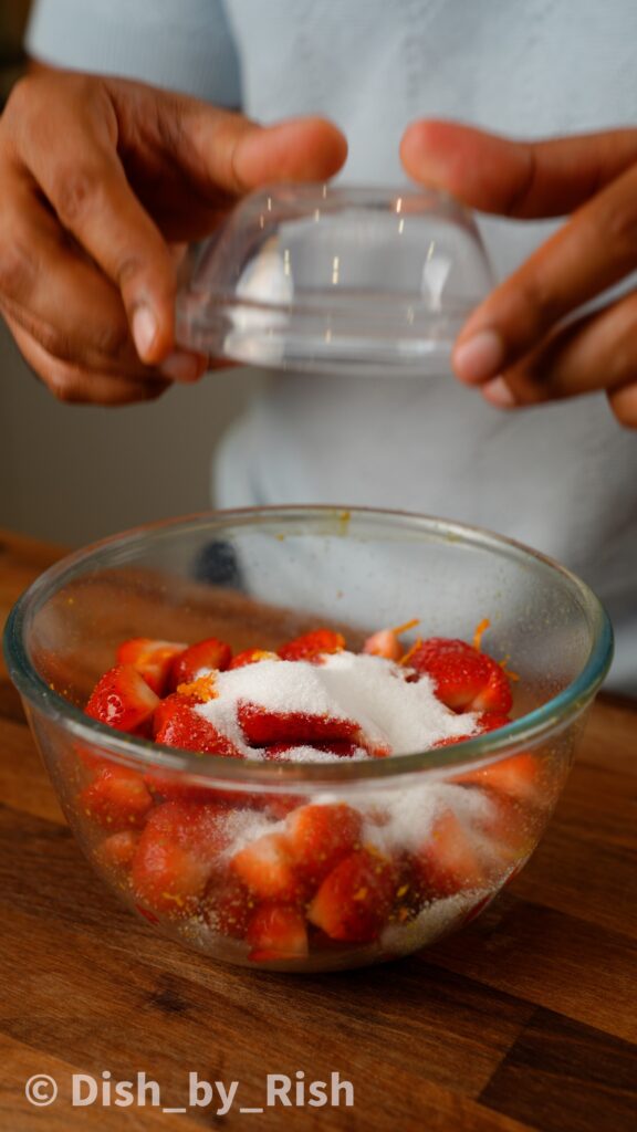 add orange zest and sugar to strawberries