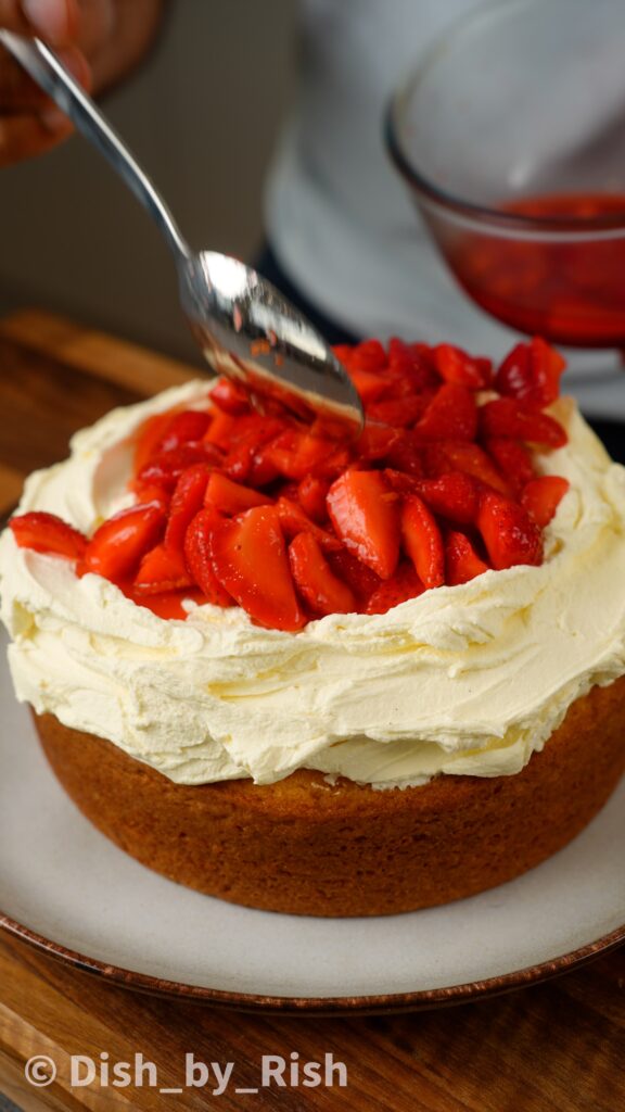 top strawberries and cream cake with macerated strawberries