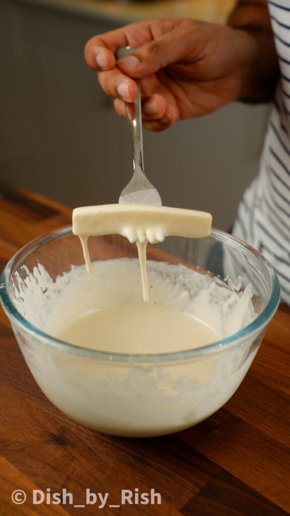 dunking mozzarella into flour paste