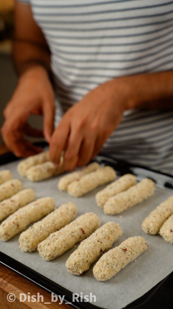 placing mozzarella sticks on lined baking tray