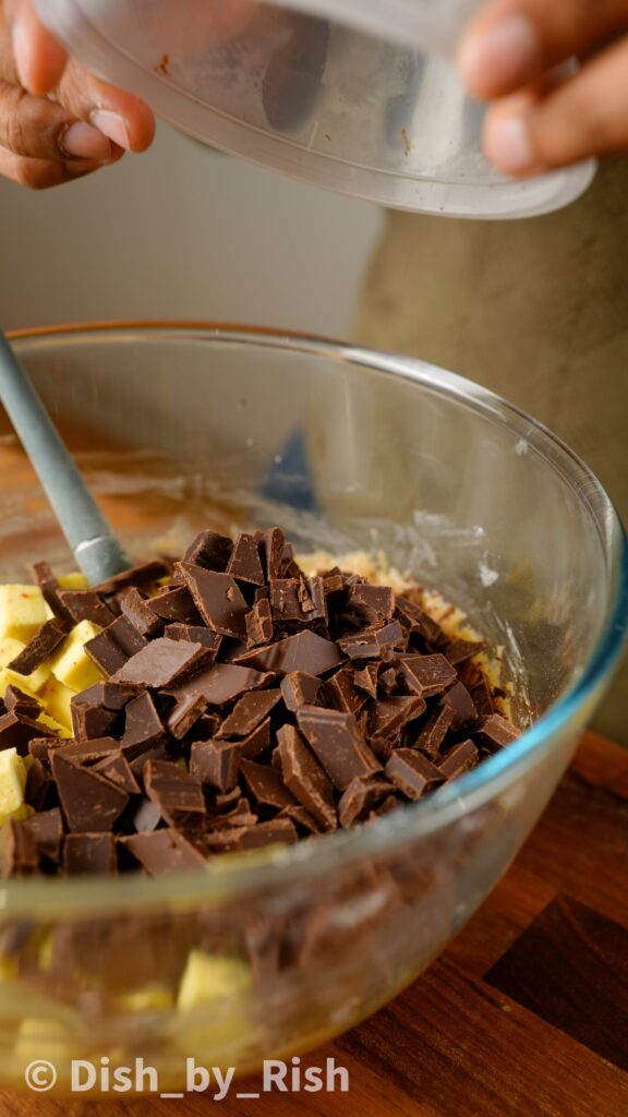 adding chopped barfi and chocolate chips to cookie dough