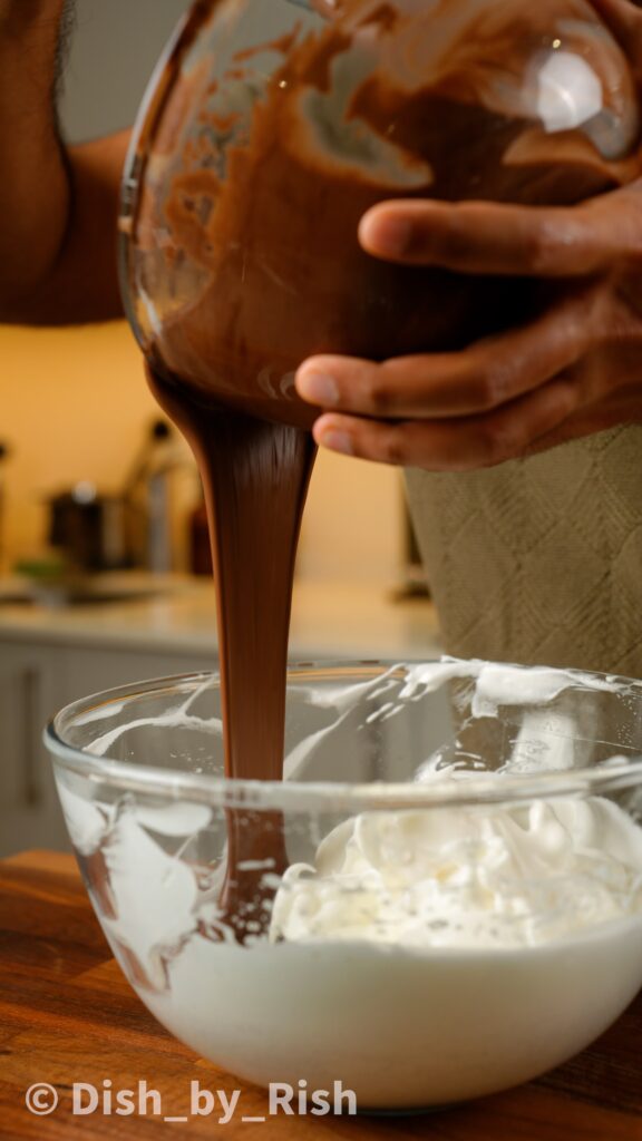 pouring yolk mixture into the bowl with the rest of the whites