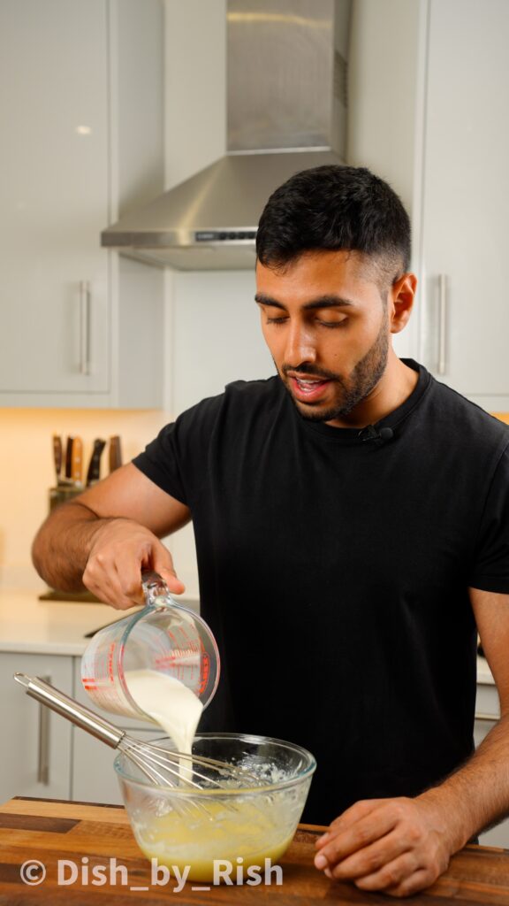 pouring in whole milk into mixing bowl