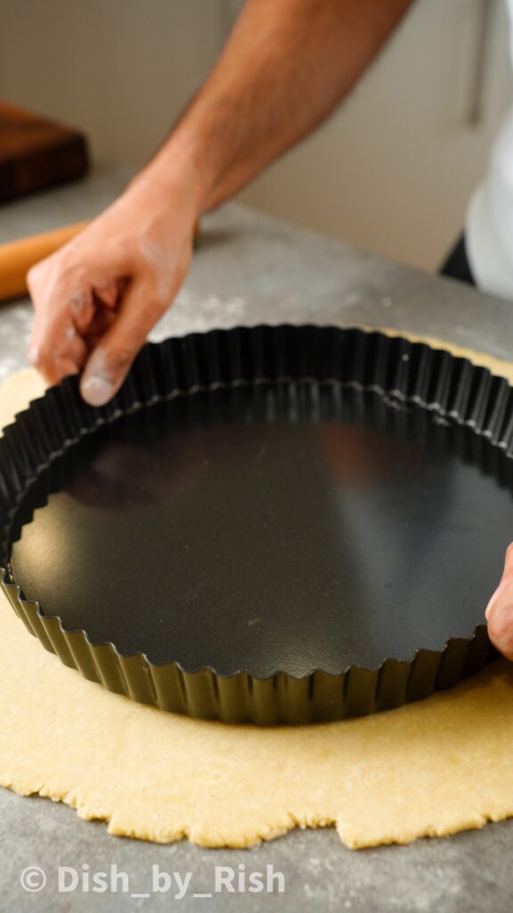 pastry dough rolled out larger than tart tin