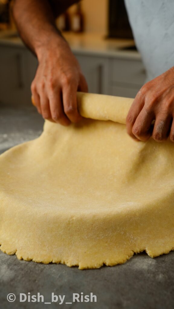 unrolling pastry over tart tin