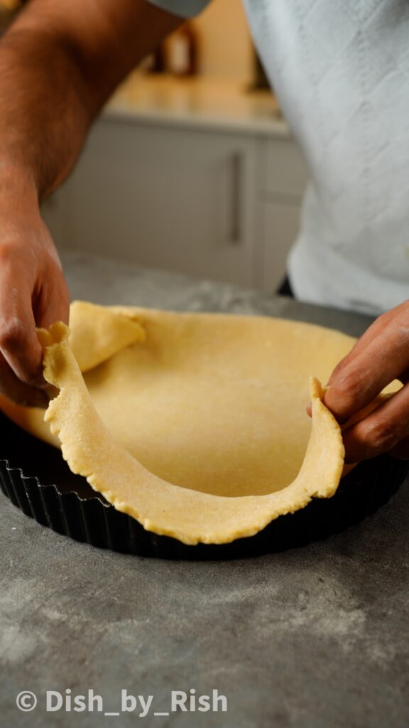 shaping pastry dough into tart tin