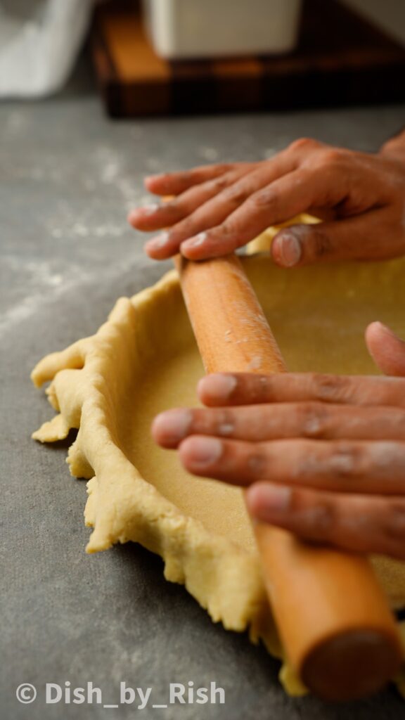 rolling pin along edge of tart tin to cut excess