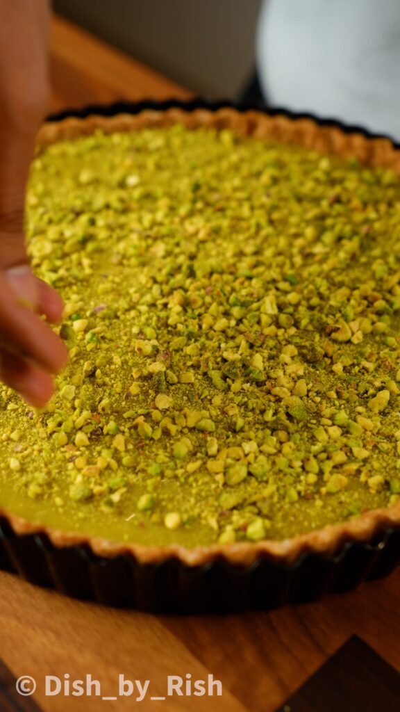 pistachios being placed on top of ganache