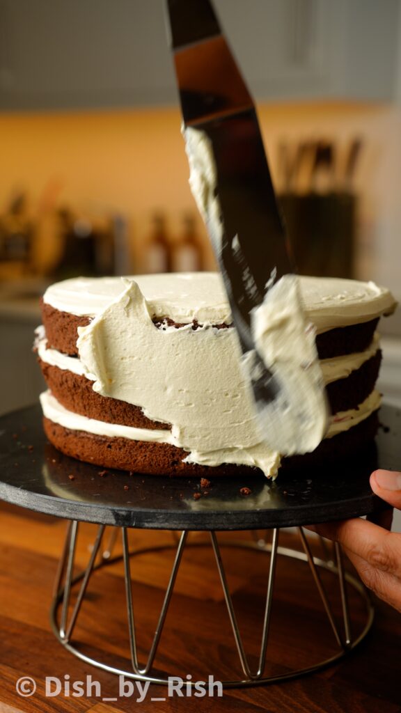 covering black forest chiffon cake with whipped cream