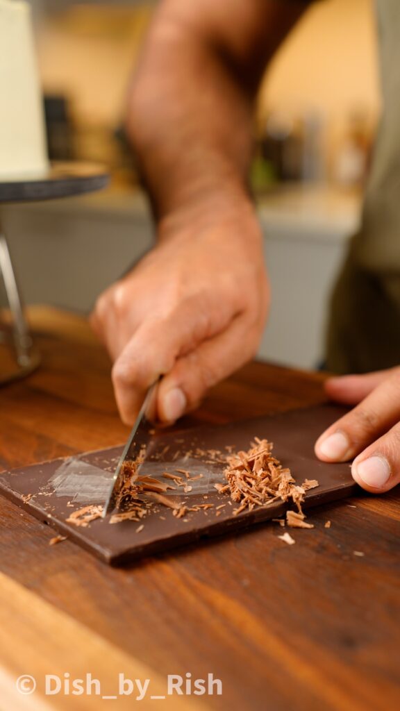 scraping dark chocolate to make chocolate shavings