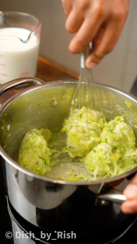 whisking roux made from flour, leeks, garlic, and thyme in butter