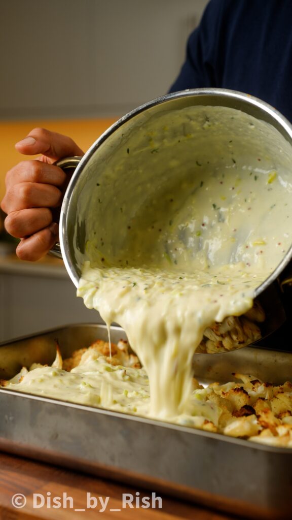 pouring truffle cheese sauce over cauliflower