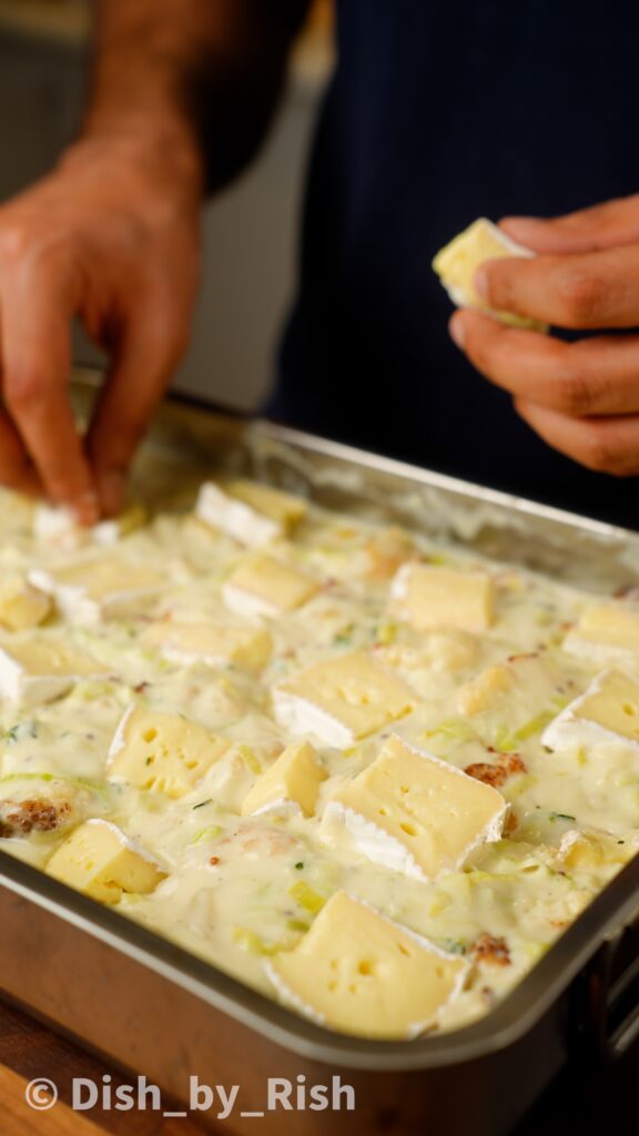 placing sliced brie on top of truffle cauliflower cheese