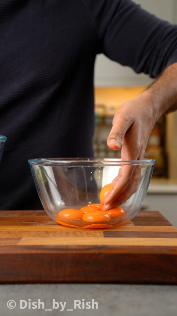 placing separated egg yolks into a bowl