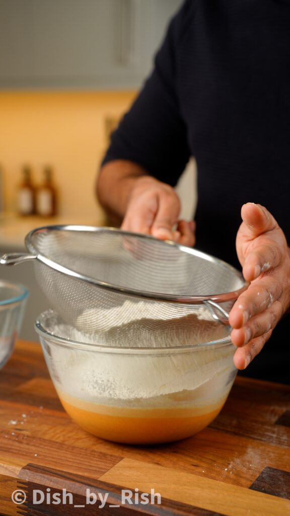 sifting dry ingredients into egg yolk mixture