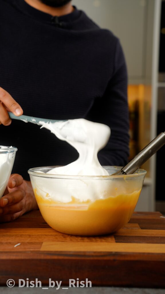 adding some of the egg whites to the yolk mixture