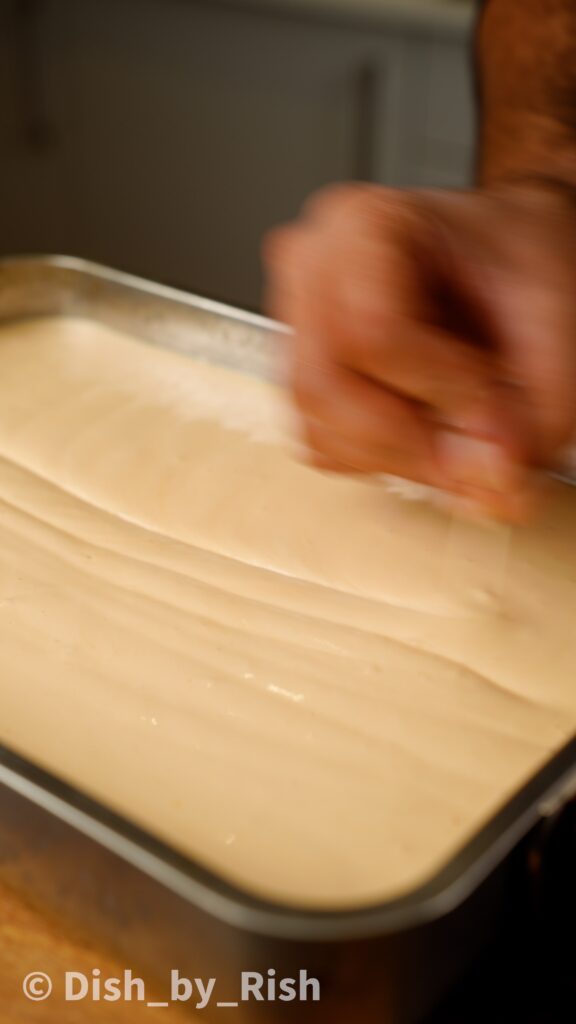 using a skewer around the chiffon cake batter in the tin