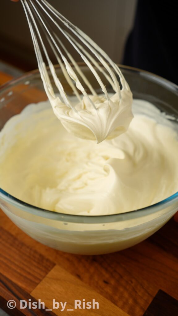 adding cream and whisking to medium peaks