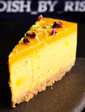 baked mango lassi cheesecake sliced and served on a plate