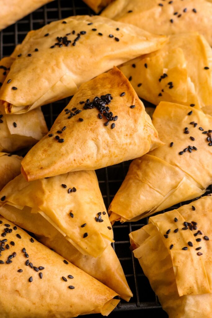 Flaky Potato and Brie Parcels stacked together on a wire rack