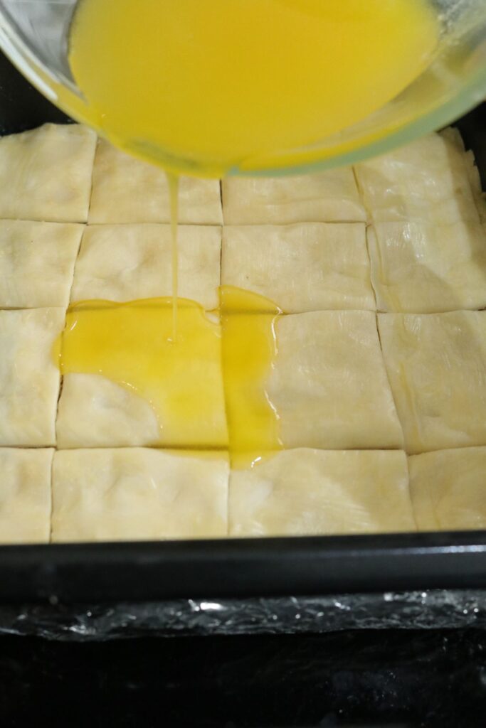 remaining clarified butter poured onto unbaked baklava