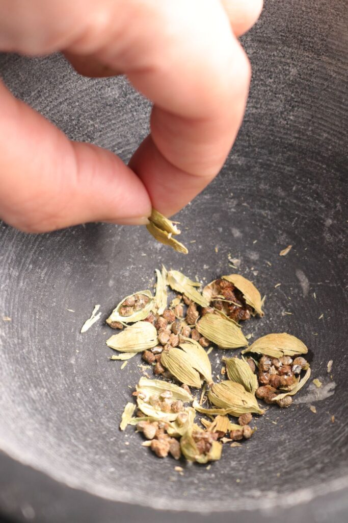 green cardamom in pestle and mortar