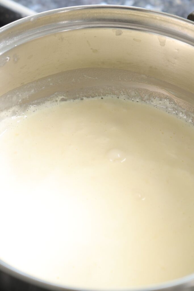 cream being heated in a saucepan till bubbles on the outside