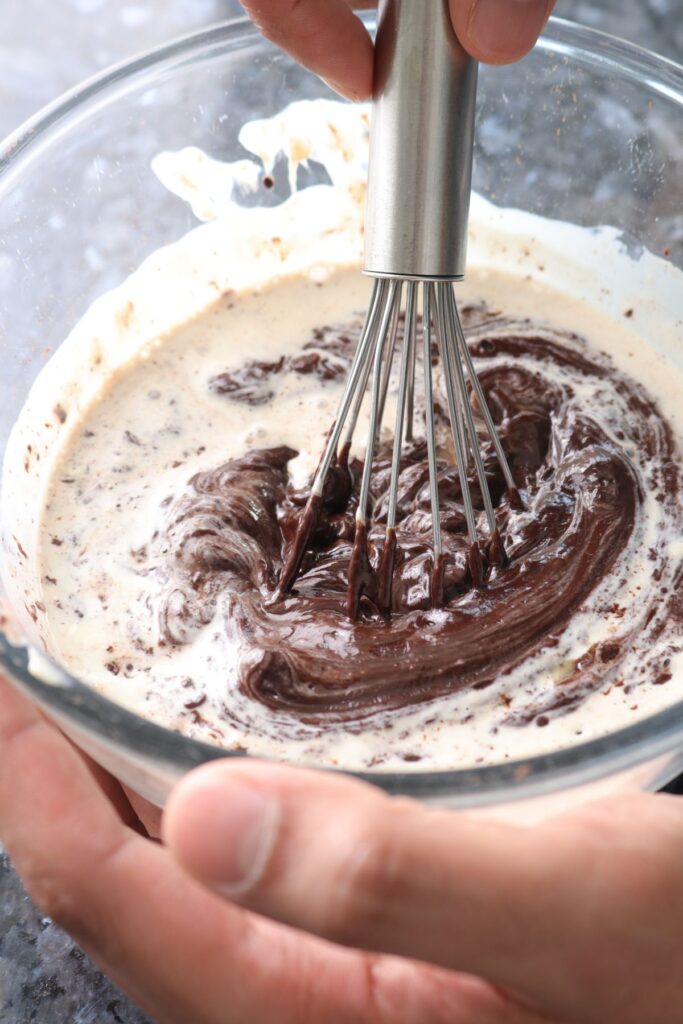 whisking chocolate, cream, and butter