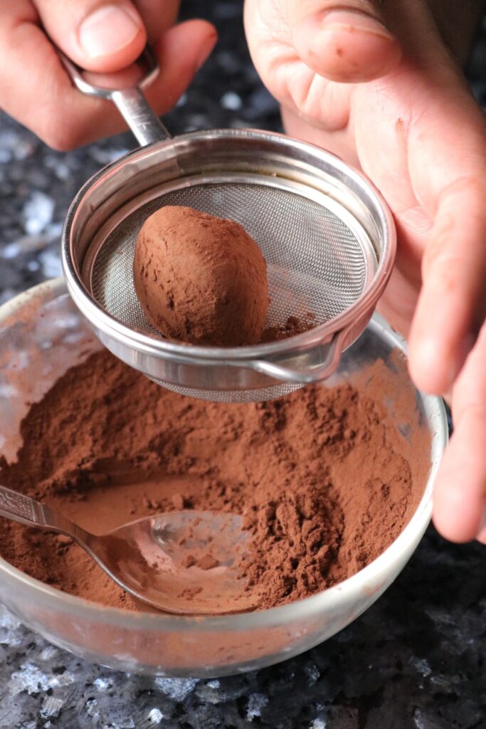 shaking off excess cocoa powder in a small sieve