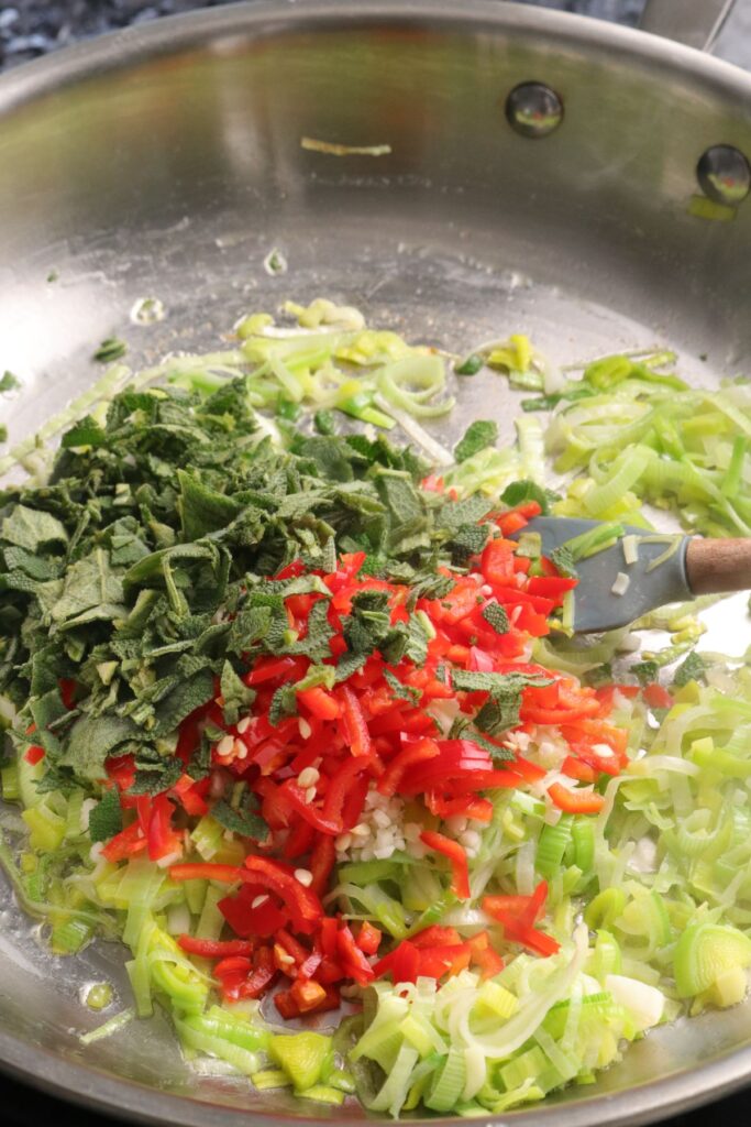 leeks, garlic, red chilli, and sage cooking in butter in a pan