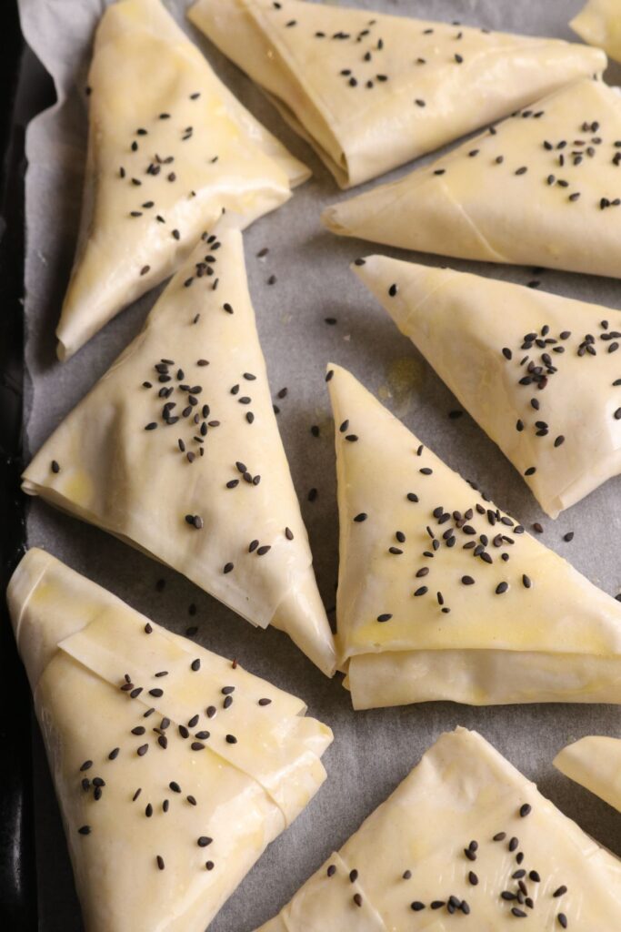 placing black sesame seeds on filo parcels